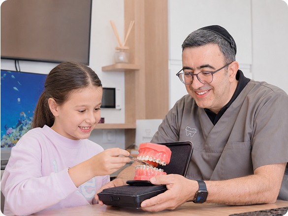 Le Dr Cohen montre un modèle de mâchoire à une enfant